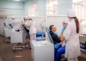 Лечебно-профилактическое отделение. Прием пациентов врачами-стоматологами терапевтами в лечебном кабинете. На первом плане проводится консультация врача-стоматолога терапевта и врача-стоматолога ортопеда.